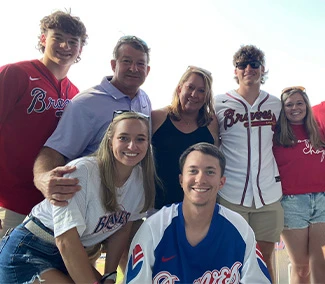 lacour family smiling in Braves jerseys at a game